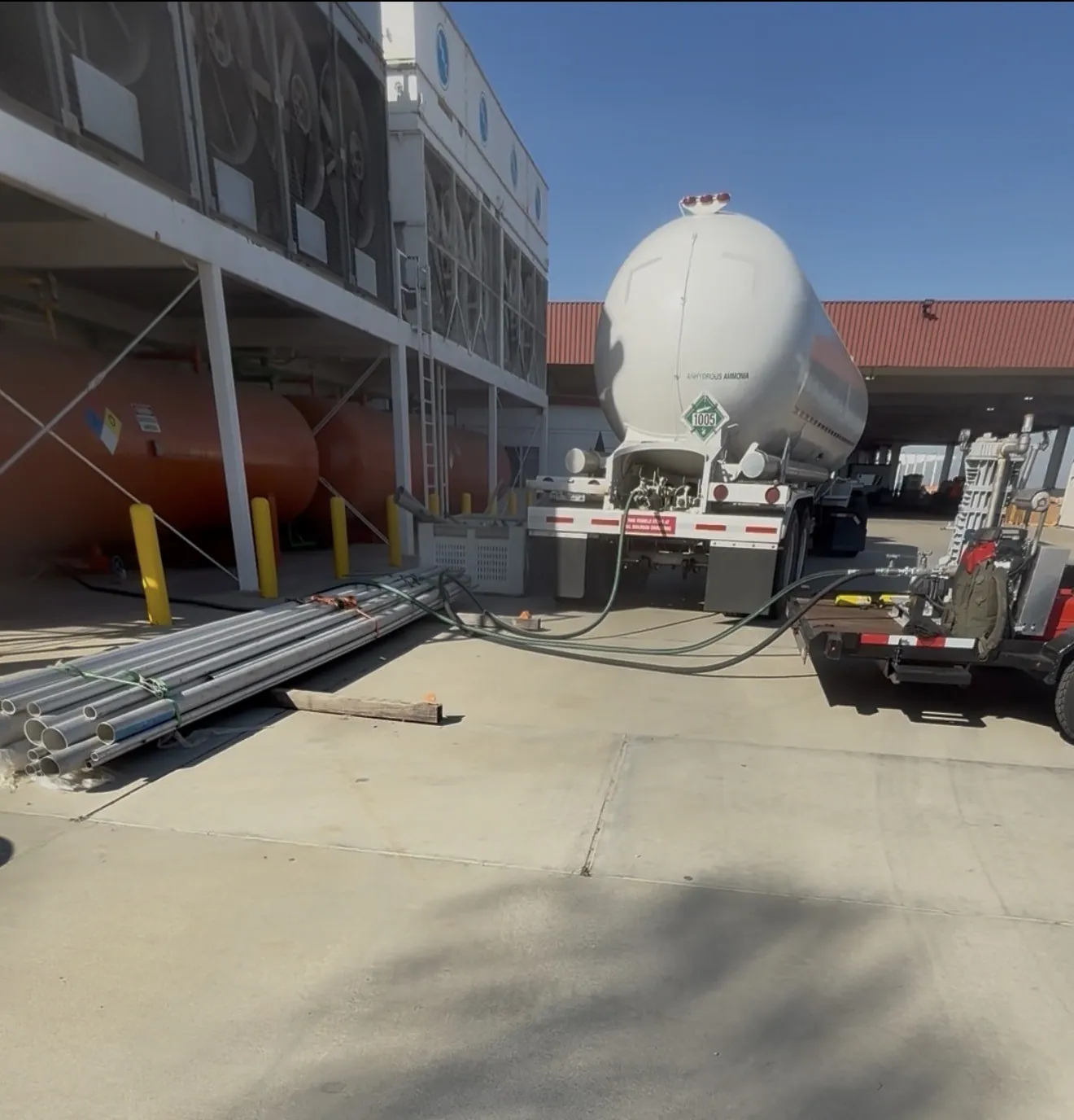 Ammonia tanker connected by transfer hoses to a plant refrigeration system