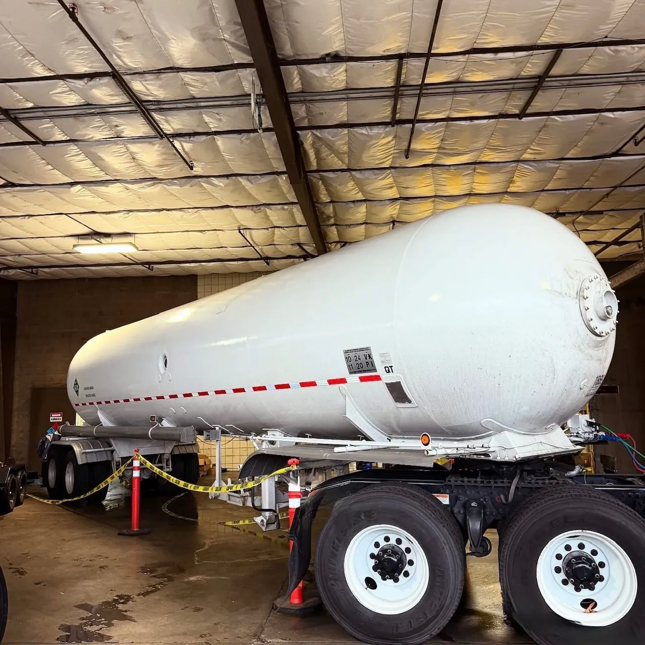 REST LLC technicians standing beside an ammonia transfer truck at an industrial facility